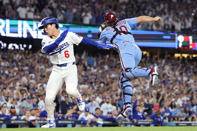 Dodgers second baseman Hyeseong Kim scores a run past Phillies catcher J.T. Realmuto on an error by reliever Orion Kerkering during the 11th inning in game 4 of the National League Division Series at Dodger Stadium on Oct. 09 in Los Angeles, California.