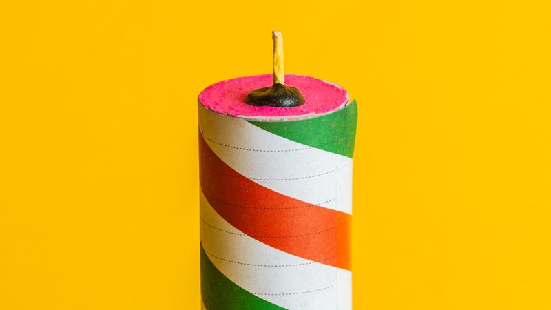 Red green striped firecracker, yellow background - stock photo