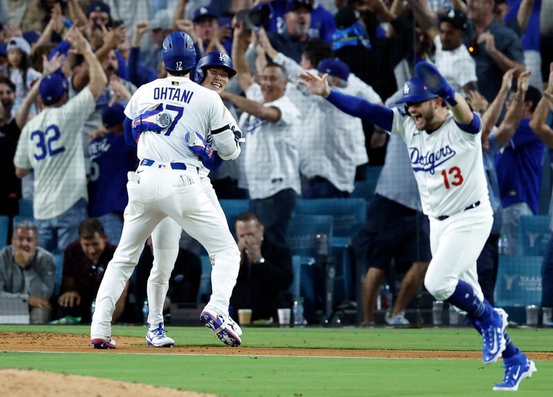 Shohei Ohtani #17 and Hyeseong Kim #6 of the Los Angeles Dodgers celebrate on the field after defeating the Philadelphia Phillies in game four of the National League Division Series at Dodger Stadium on October 09, 2025 in Los Angeles, California.