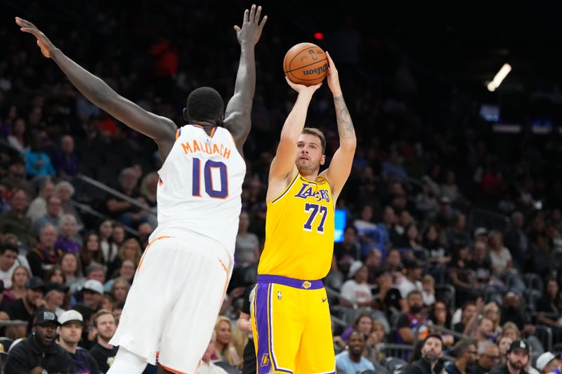 Luka Doncic #77 of the Los Angeles Lakers attempts a shot against Khaman Maluach #10 of the Phoenix Suns during the first half of the preseason NBA game at Mortgage Matchup Center on October 14, 2025 in Phoenix, Arizona.
