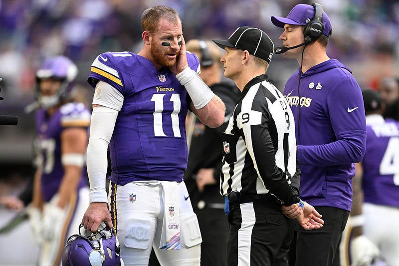 Carson Wentz #11 of the Minnesota Vikings talks with an official during the fourth quarter against the Philadelphia Eagles in the game at U.S. Bank Stadium on October 19, 2025 in Minneapolis, Minnesota.