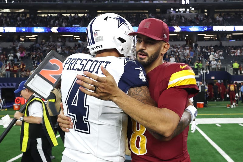 ARLINGTON, TEXAS - OCTOBER 19: Dak Prescott #4 of the Dallas Cowboys and Marcus Mariota #8 of the Washington Commanders hug after Dallas' 44-22 victory at AT&T Stadium on October 19, 2025 in Arlington, Texas. (Photo by Stacy Revere/Getty Images)
