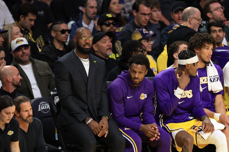 side line of baskball game with lakers players on the bench