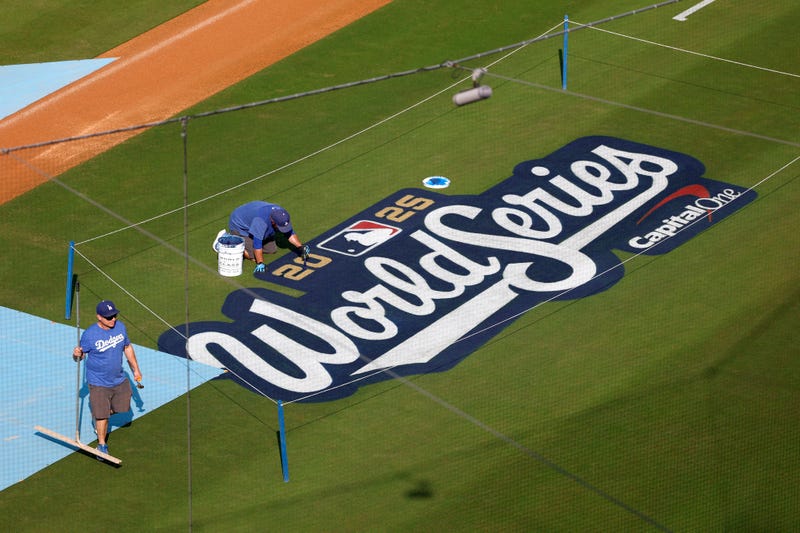 Grounds crew members paint the 2025 World Series logo on the infield during a World Series workout day at Dodger Stadium on October 26, 2025 in Los Angeles, California.