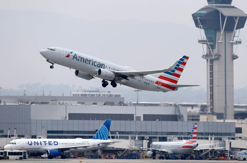 An American Airlines jet takes off with a United aircraft in the background