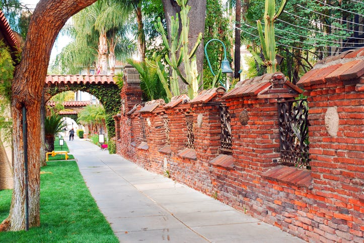 A brick wall, built in the Mission stye surrounds the Mission Inn, a historic hotel in Riverside California