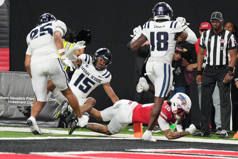 Kayden McGee #16 of the UNLV Rebels scores the game-winning touchdown in double overtime to defeat the Utah State Aggies 29-26 at Allegiant Stadium on November 15, 2025 in Las Vegas, Nevada. 