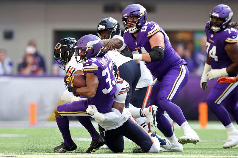 Aaron Jones #33 of the Minnesota Vikings is tackled by Dominique Robinson #90 of the Chicago Bears during the first quarter at U.S. Bank Stadium on November 16, 2025 in Minneapolis, Minnesota. 