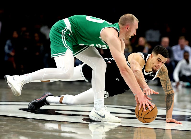 Sam Hauser #30 of the Boston Celtics and Michael Porter Jr. #17 of the Brooklyn Nets dive for a loose ball during their game at Barclays Center on November 18, 2025 in New York City.