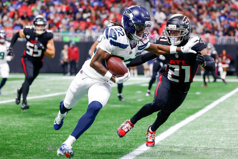 Rashid Shaheed of the Seattle Seahawks avoids a tackle from Mike Hughes of the Atlanta Falcons