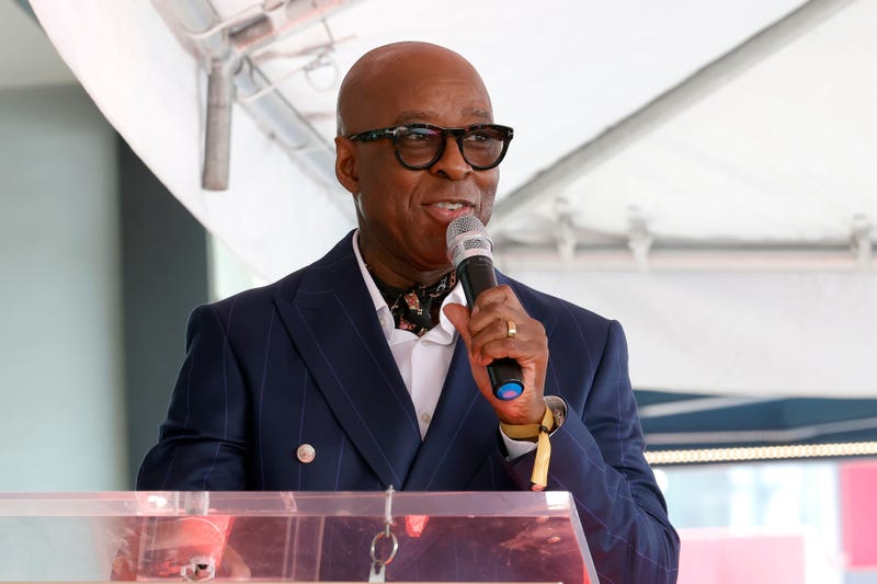 Courtney B. Vance stands at podium with microphone in hand