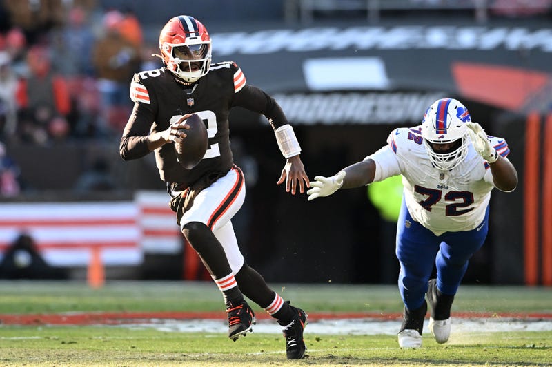Shedeur Sanders #12 of the Cleveland Browns escapes the defense of Phidarian Mathis #72 of the Buffalo Bills in the third quarter of the game at Huntington Bank Field on December 21, 2025 in Cleveland, Ohio.