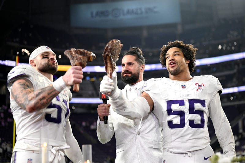Blake Cashman #51 and Eric Wilson #55 of the Minnesota Vikings celebrate with steak as they are interviewed by Seth Rollins following their 23-10 win against the Detroit Lions at U.S. Bank Stadium on December 25, 2025 in Minneapolis, Minnesota. 