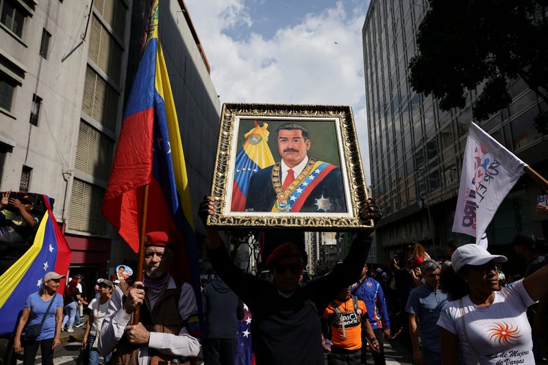 CARACAS, VENEZUELA - JANUARY 6: A man holds a portrait of Nicolas Maduro during a march in his support and his wife Cilia Flores after their capture by U.S. forces, on January 6, 2026 in Caracas, Venezuela. U.S. President Donald Trump announced on January 3 that his country's military had launched a large-scale attack on Venezuela and captured its President Nicolas Maduro, and his wife, Cilia Flores. As citizens start to struggle with the lack of supplies and water, the National Assembly has appointed Vice President Delcy Rodriguez as Acting President. (Photo by Jesus Vargas/Getty Images)