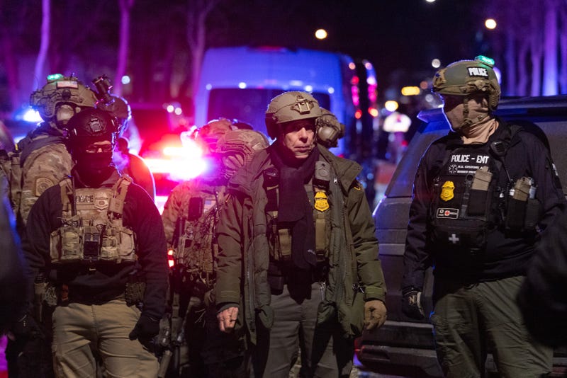 Border Patrol Chief Gregory Bovino and other federal agents guard a perimeter following a shooting incident as angry residents protest their presence in the city on January 14, 2026 in Minneapolis, Minnesota