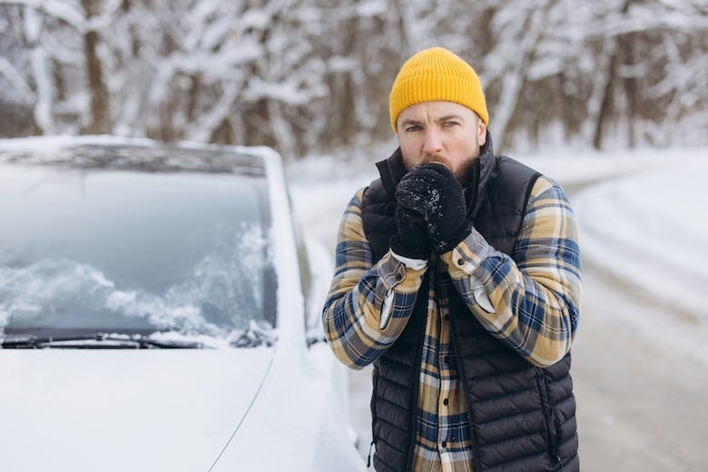 Man stranded on the side of the road during a snowstorm