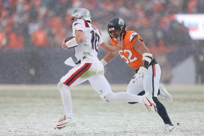 Drake Maye #10 of the New England Patriots stiff arms Jonah Elliss #52 of the Denver Broncos during the fourth quarter in the AFC Championship Playoff game at Empower Field At Mile High on January 25, 2026 in Denver, Colorado.