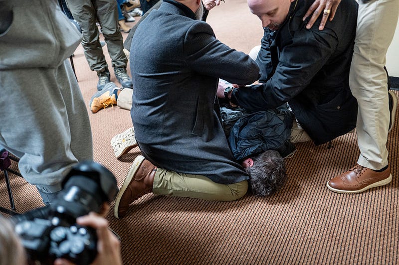 A person is subdued after attempting to attack Rep. Ilhan Omar (D-MN) during a town hall meeting at the Urban League Twin Cities facility on January 27, 2026 in Minneapolis, Minnesota. A person holding a syringe charged Omar's podium while she spoke to community members. Protests and demonstrations continue around Minneapolis in the aftermath of the killings of Alex Pretti and Renee Nicole Good by federal law enforcement. 