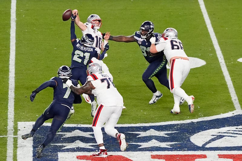 Devon Witherspoon #21 of the Seattle Seahawks forces a interception against Drake Maye #10 of the New England Patriots during the fourth quarter in Super Bowl LX at Levi's Stadium on February 08, 2026 in Santa Clara, California. The ball was returned for a TD by #7 Uchenna Nwosu.