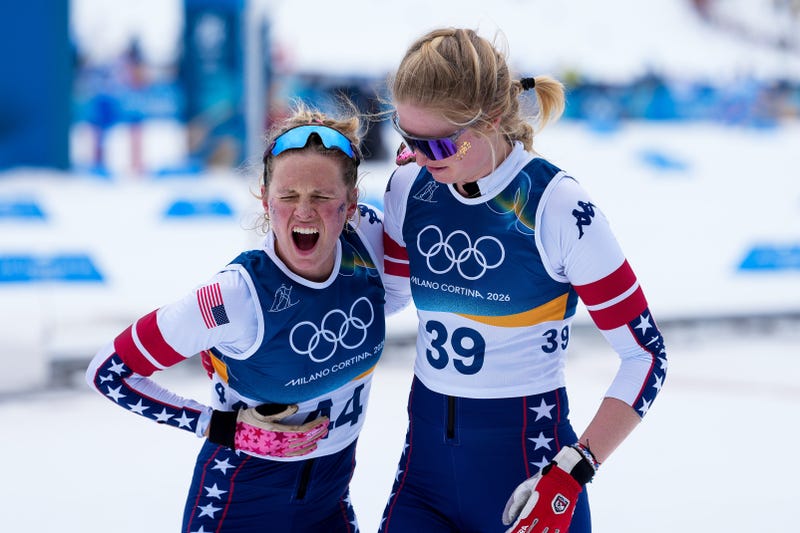 Hailey Swirbul (right) of Team United States, Jessie Diggins (left) of Team United States celebrate on day six of the Milano Cortina 2026 Winter Olympic games at Tesero Cross-Country Skiing Stadium on February 12, 2026 in Val di Fiemme, Italy. Diggins won bronze despite very painful bruised ribs in the demanding 10K race.