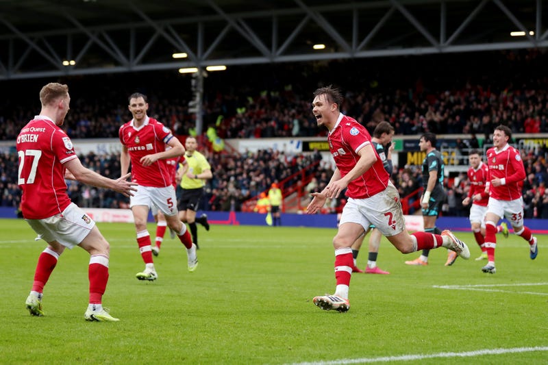 Callum Doyle of Wrexham celebrates scoring his team's fourth goal with teammate Lewis O'Brien during the Sky Bet Championship match between Wrexham AFC and Ipswich Town at Racecourse Ground on February 21, 2026 in Wrexham, Wales.