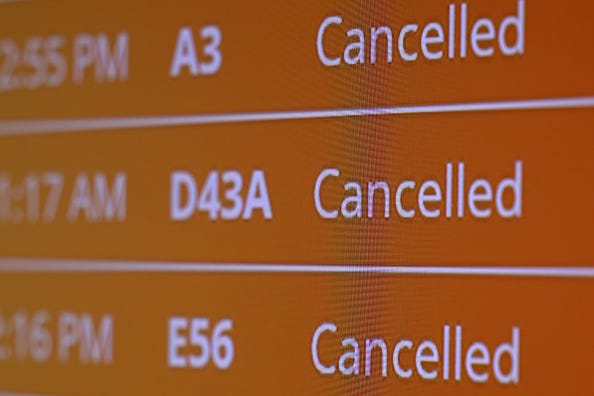 Flight cancellations are displayed on a bulletin board at Ronald Reagan Washington National Airport on February 23, 2026 in Arlington, Virginia. 