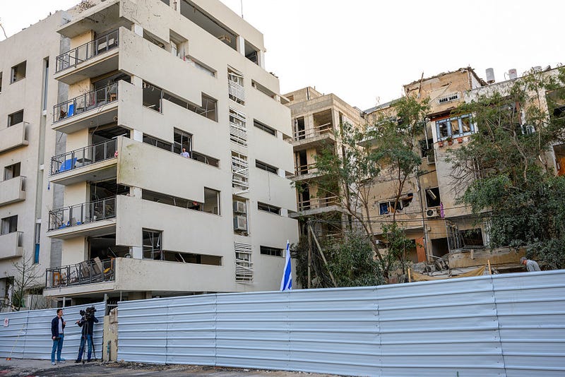 People visit the site of a missile strike a few days earlier after the destroyed building was razed on March 03, 2026 in Tel Aviv, Israel.