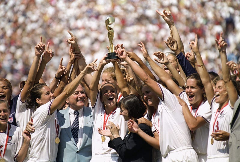Richardson, Texas native and captain Carla Overbeck #4 of the U.S. Women's Soccer Team raises the World Cup Trophy, as the team celebrates their victory over Team China in the Championship match of the FIFA Women's World Cup at the Rose Bowl on July 10, 1999, in Pasadena, California.