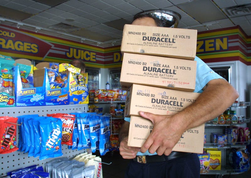 A worker carries a fresh load of batteries into a gas station convenience store after their supply was exhausted by a rush of people trying to stock up August 15, 2003 in Royal Oak, Michigan.