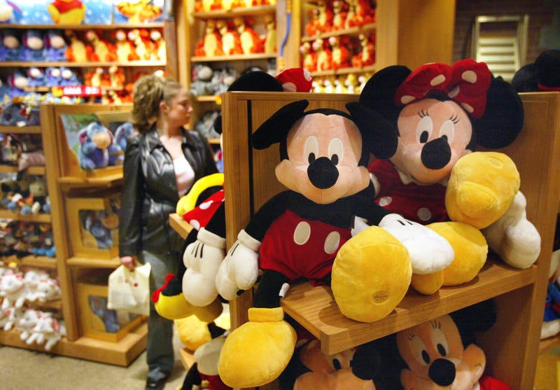 CHICAGO - MARCH 15: A woman shops for items behind Mickey and Minnie Mouse stuffed toys in a Disney Store March 15, 2004 in Chicago. Disney is still planning to sell two money losing ventures, the Disney Stores and the Mighty Ducks hockey team