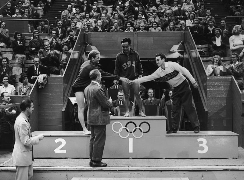 Olympic medal ceremony at the Empire Pool, Wembley. Men's Platform Diving, Bruce Harlan (USA) second congratulates Joaquin Capilla Perez (Mexico) third and Samuel Lee (USA) winner.
