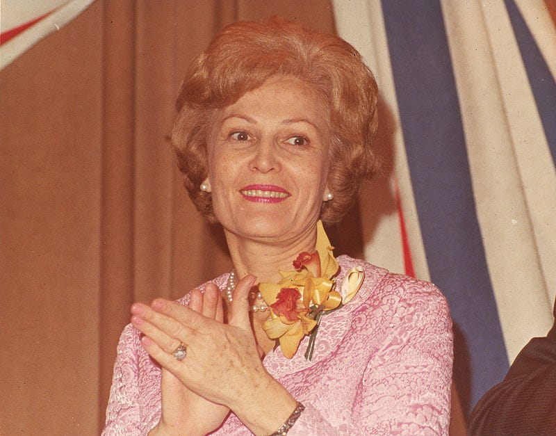 Portrait of former First Lady Pat Nixon (1912 - 1993) , wife of American President Richard Nixon, wearing a pink suit and clapping, circa 1980s. 