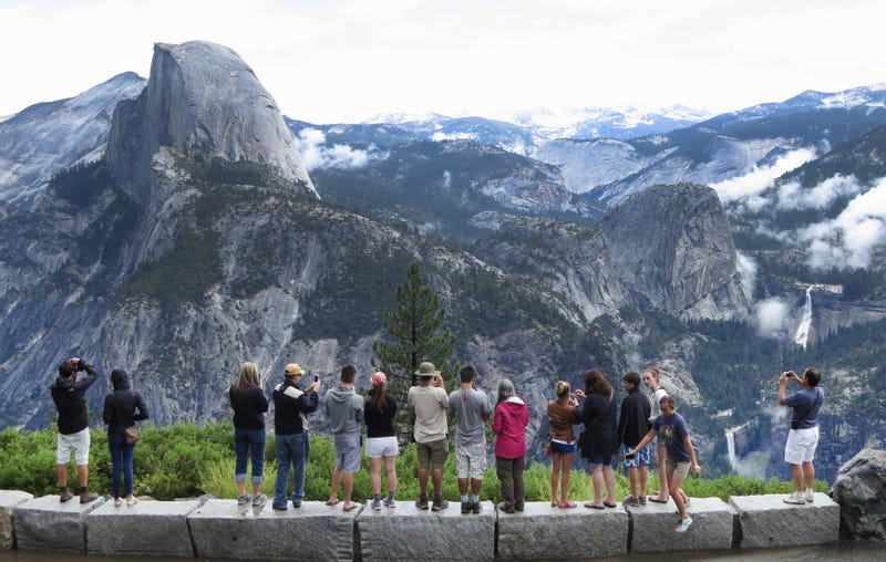 Visitors look out at Yosemite National Park from Glacier Point on July 21, 2014 in Yosemite National Park, California.