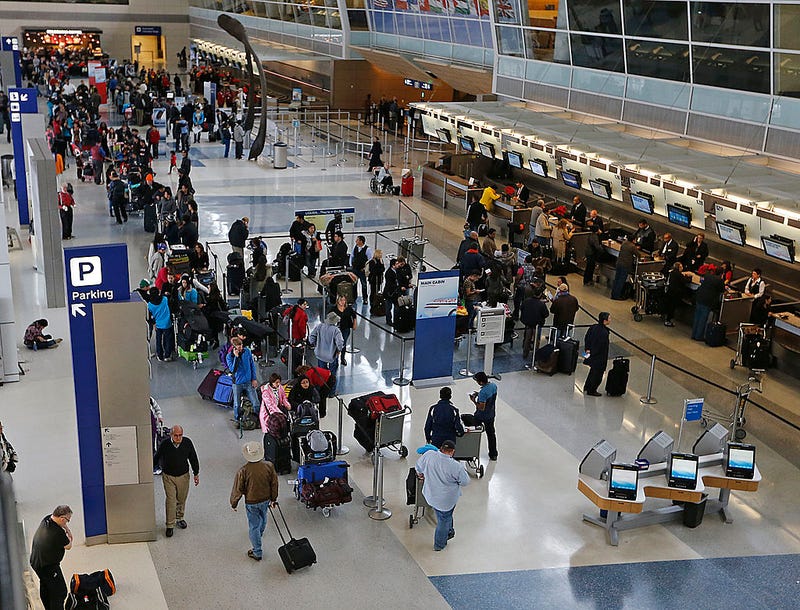 Passengers waiting to speak with ticket agents at American Airlines line the length of Terminal D at DFW International Airport