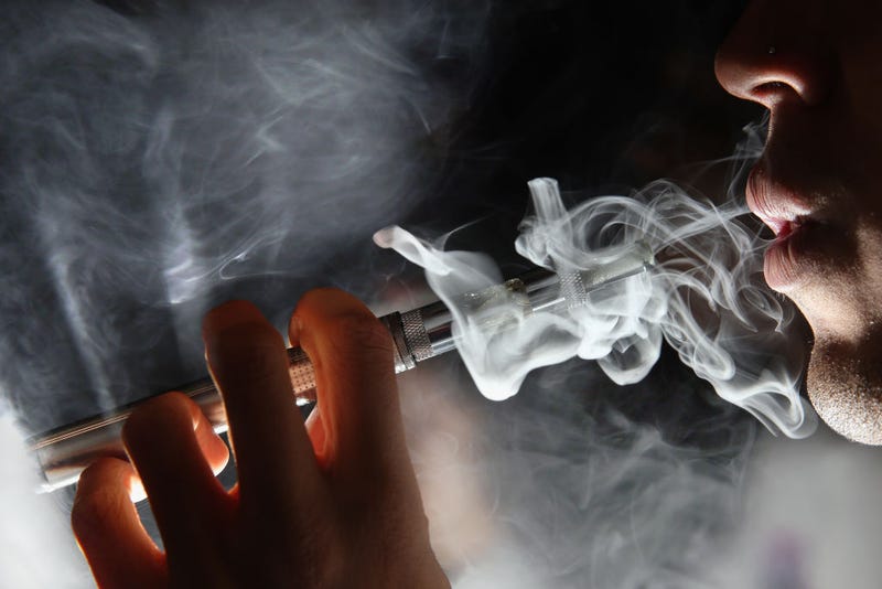 In this photo illustration, a man smokes an E-Cigarette at the V-Revolution E-Cigarette shop in Covent Garden on August 27, 2014 in London, England.
