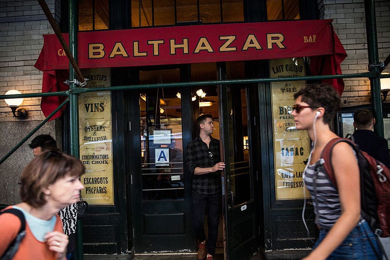 People walk past the restaurant Balthazar on September 10, 2014, in the SoHo neighborhood of New York City.