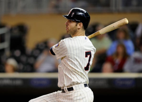 : Joe Mauer #7 of the Minnesota Twins hits an RBI single against the Detroit Tigers during the eighth inning of the game on September 17, 2014 at Target Field in Minneapolis, Minnesota. The Twins defeated the Tigers 8-4. 