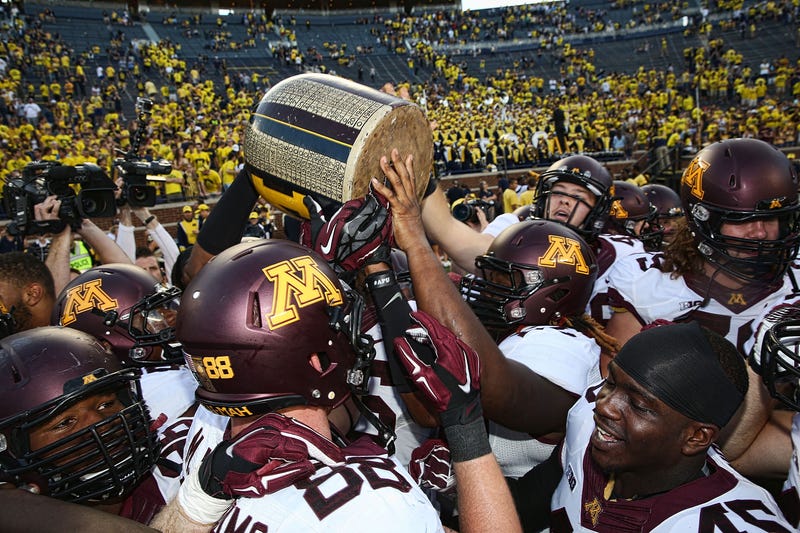 Members of the Minnesota Golden Gophers celebrate a win over the Michigan Wolverines with the Little Brown Jug at Michigan Stadium on September 27, 2014 in Ann Arbor, Michigan.
