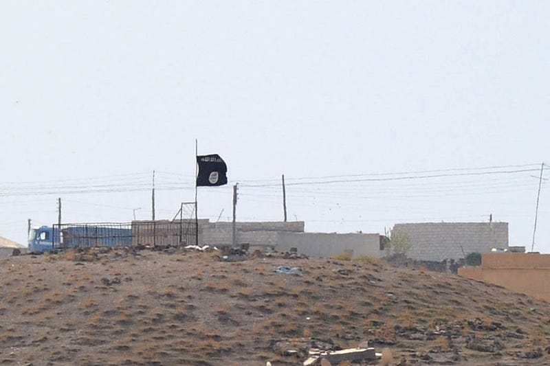 A Islamic State (ISIS) black flag flies neasr the Syrian town of Kobani, October 27, 2014 as seen from the Turkish-Syrian border near the southeastern town of Suruc in Sanliurfa province, Turkey. 