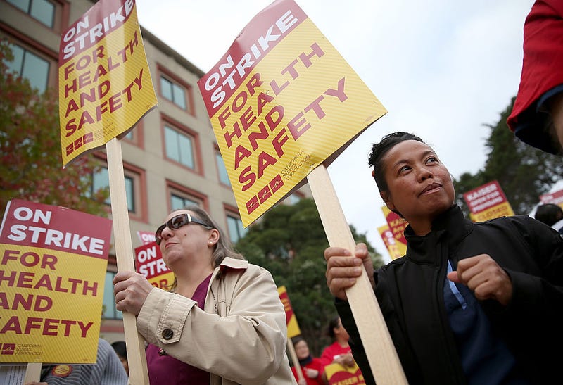 Nurses carry signs as they strike outside of Kaiser Permanente hospital on November 11, 2014 in San Francisco, California.