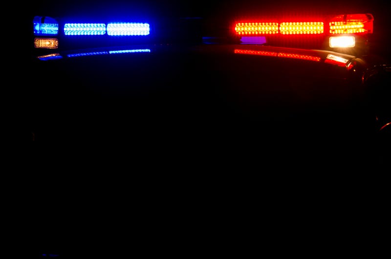 The top of a police car at night with its lights on