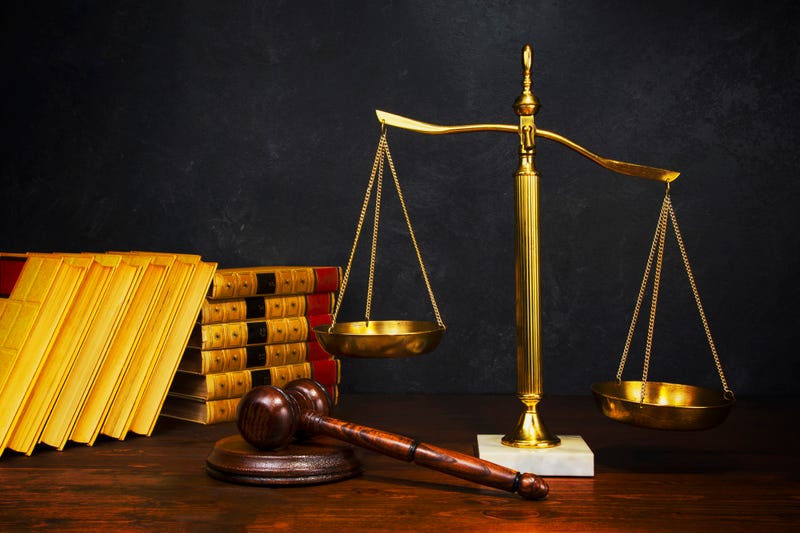 Scales of Justice with gavel and old law books in the background