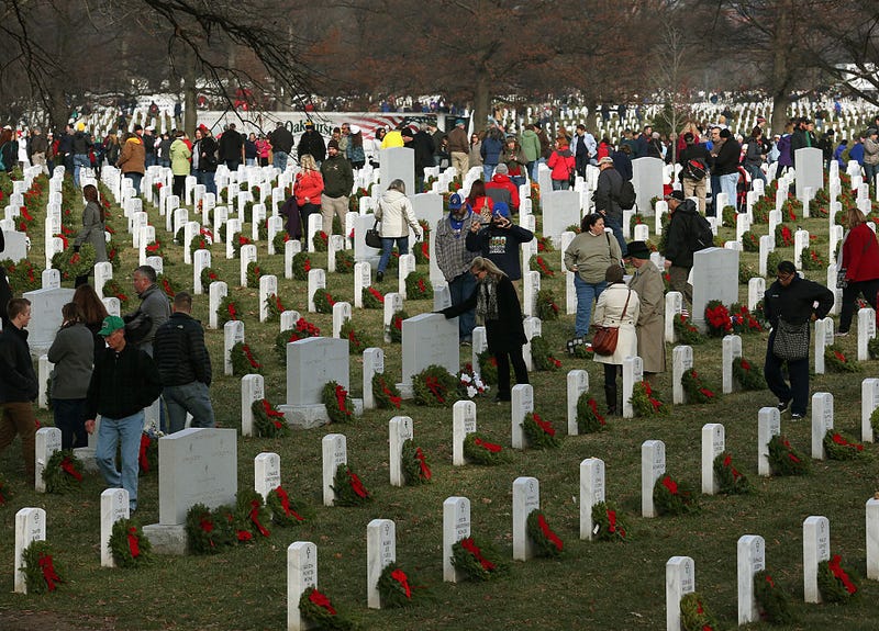 Volunteers gather in Section 60 to place wreaths on graves during the National Wreaths Across America Day at Arlington National Cemetery, December 13, 2014 in Arlington, Virginia. Volunteers placed wreaths throughout the entire cemetery in honor of Arlington's 150th anniversary.