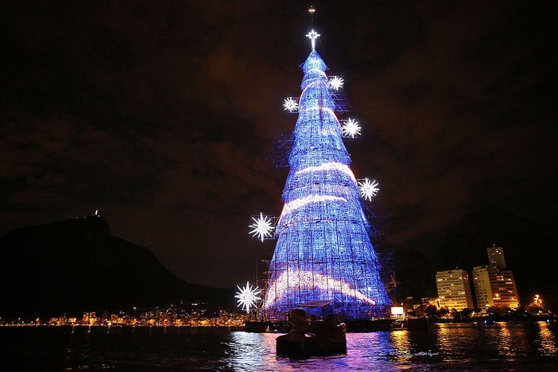 Brazilians paddle past the world's largest floating Christmas tree on December 21, 2014 in Rio de Janeiro, Brazil. The tree is 85-meters tall and features over 3 million light bulbs.