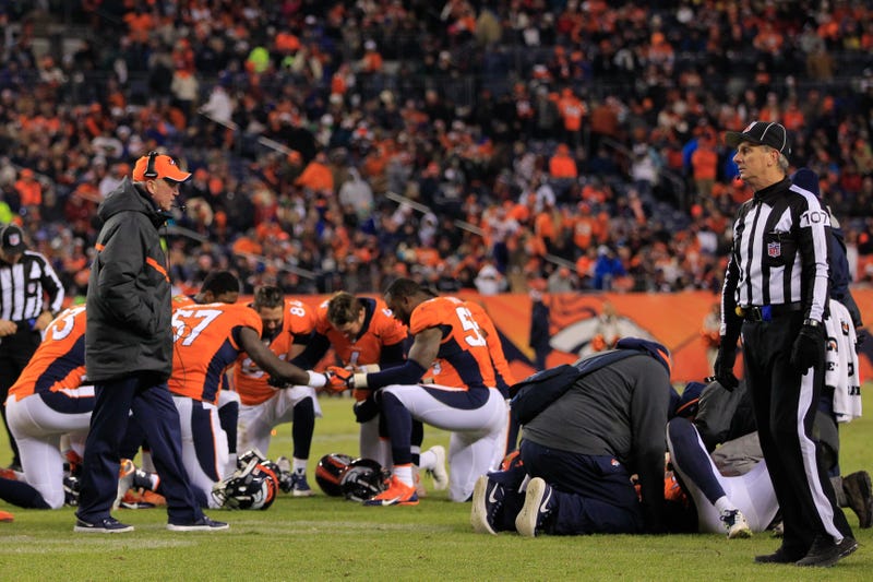 Players gather in prayer after a teammate suffers a concussion during an NFL game.