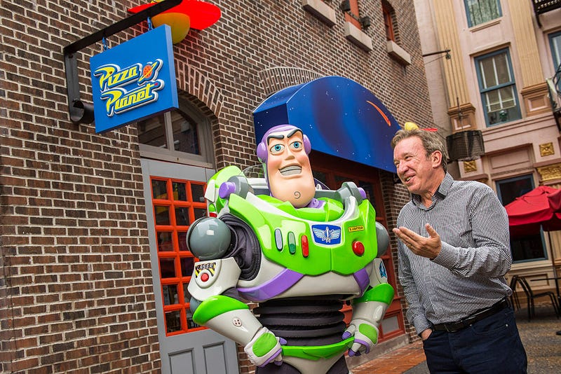 In this handout photo provided by Disney Parks, actor and comedian Tim Allen, the voice of Buzz Lightyear in the Disney-Pixar "Toy Story" series of animated films, poses with Buzz Lightyear December 31, 2014 at Disney's Hollywood Studios theme park in Lake Buena Vista, Florida.