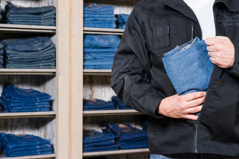Man stealing jeans from a store