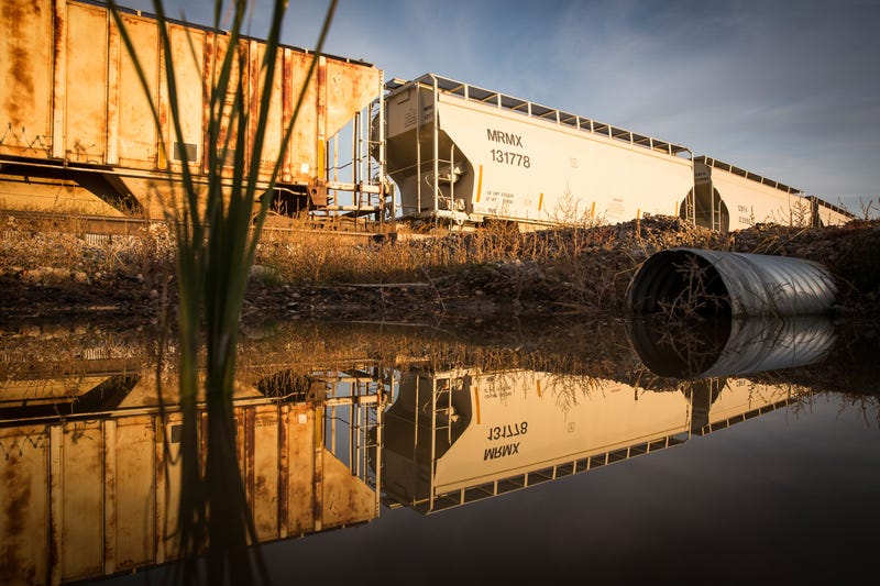 Train cars sit next to miles of unused pipe (unseen), prepared for the proposed Keystone XL pipeline, on October 14, 2014 outside Gascoyne, North Dakota.