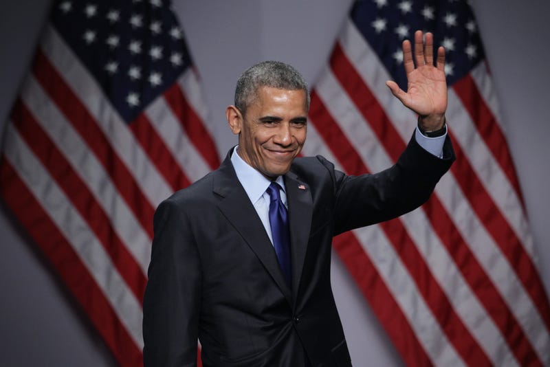 Barack Obama in front of two American flags
