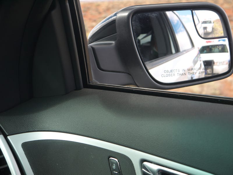 driver pulled over by police, pictured in rearview mirror